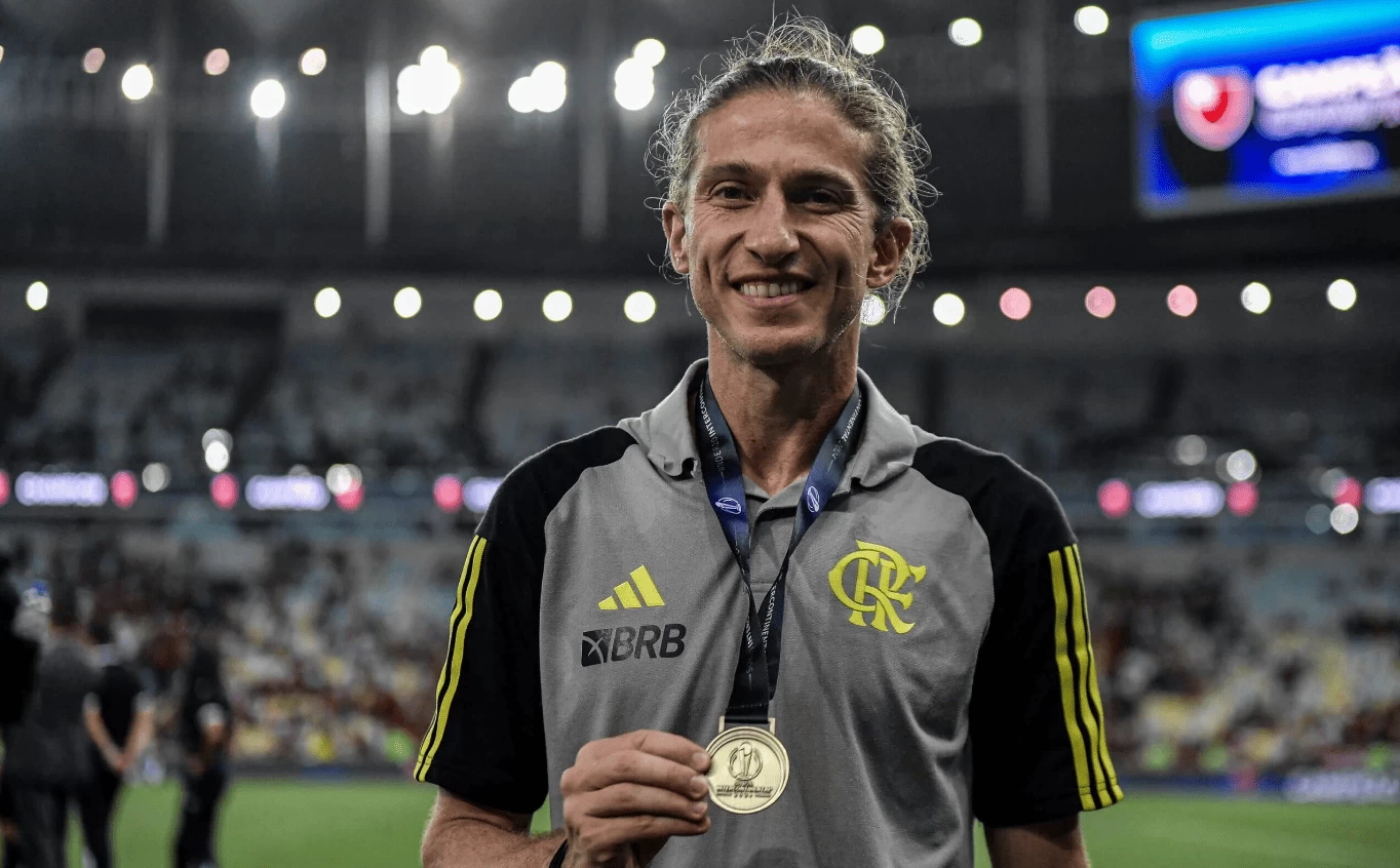 Filipe Luís no campo, um dos ex-jogadores que viraram técnicos de seus clubes, no campo, segurando medalha