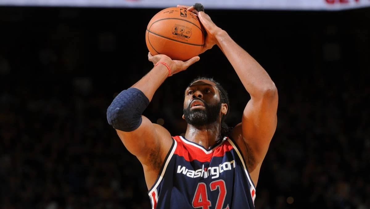 Nenê Hilário segurando uma bola de basquete na quadra