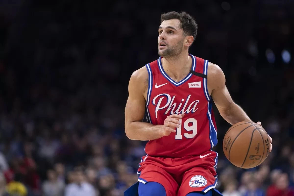 Raulzinho, um dos jogadores brasileiros da NBA, em quadra, segurando uma bola de basquete