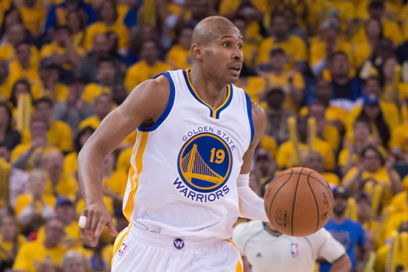 Leandrinho em quadra, com a bola de basquete na mão e uniforme do Warriors