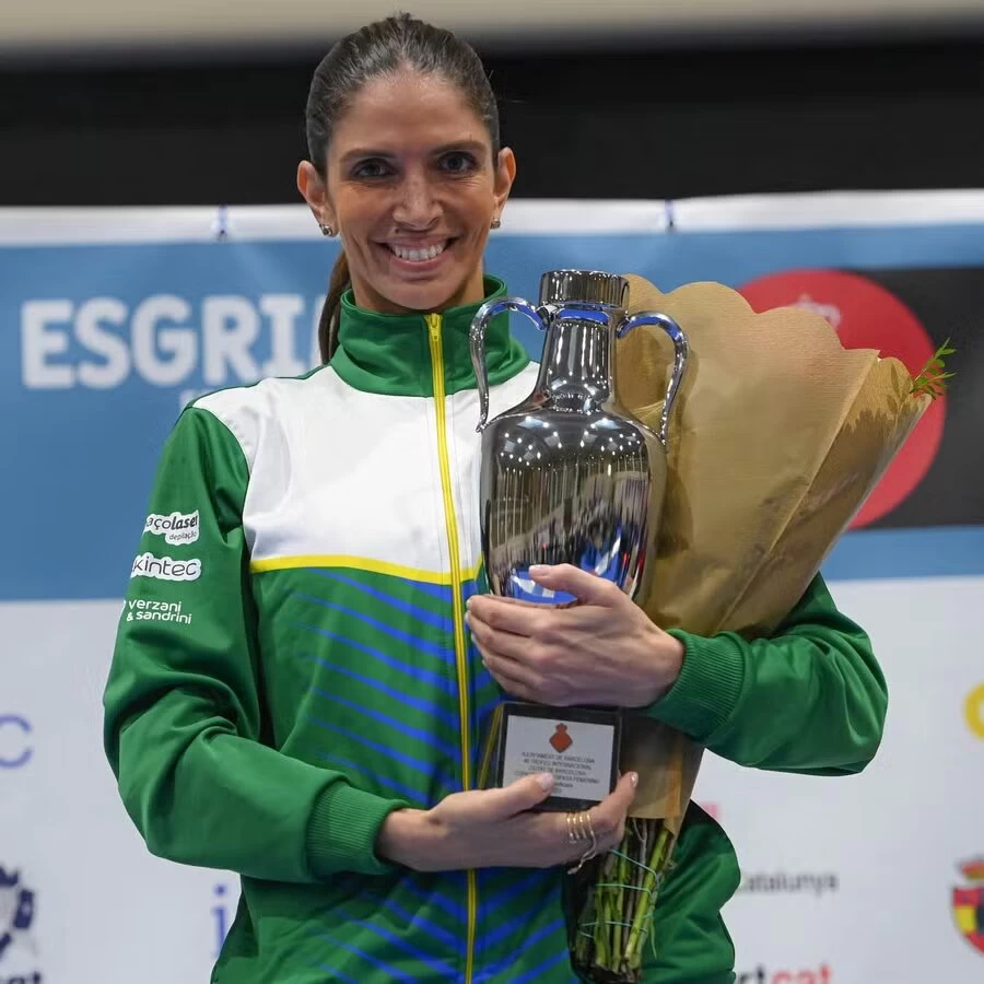 Natalie Moellhausen, esgrimista brasileira, comemora sua vitória segurando o troféu