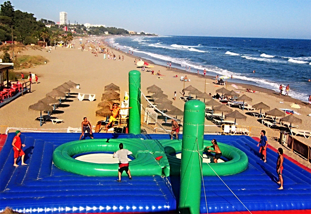 Pessoas praticando Bossaball na praia