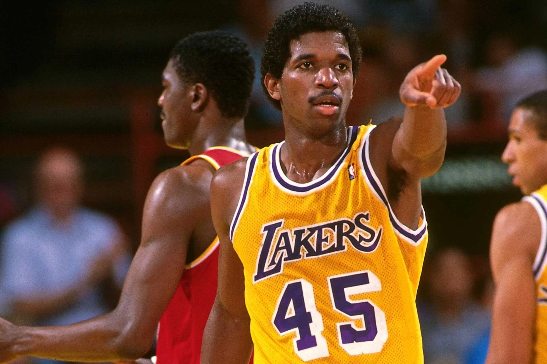 Foto de A.C Green, em quadra, apontando para algo. O jogado é dono de um dos maiores recordes da NBA